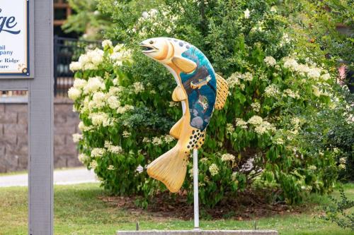 a statue of a fish on a pole in the grass at Penthouse Suite Right in the Heart of Downtown - Trackside in Blue Ridge