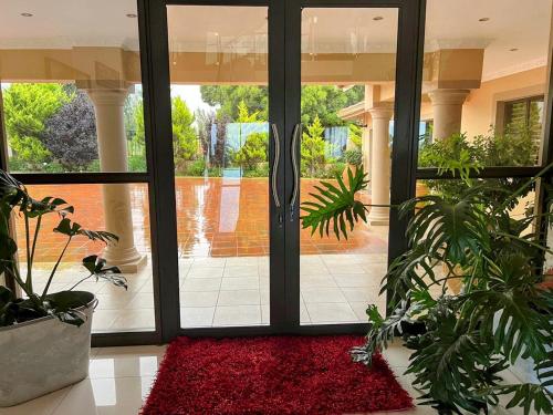 a room with a glass door with a red rug at Ambience on N2 Boutique Hotel in Kokstad