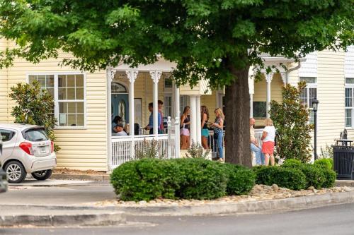 a group of people standing on the porch of a house at Penthouse Suite Right in the Heart of Downtown - Trackside in Blue Ridge