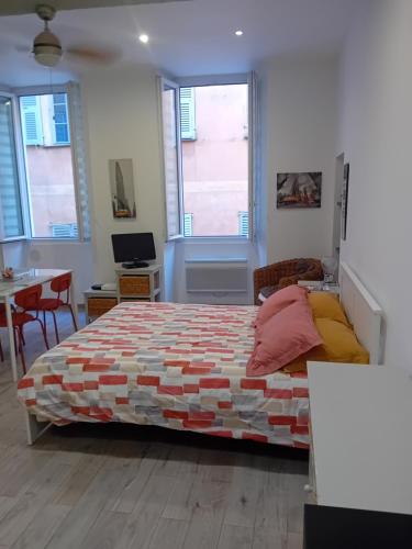 une chambre avec un lit et un bureau et deux fenêtres dans l'établissement Nice Studio Old Town Sea Side, à Nice