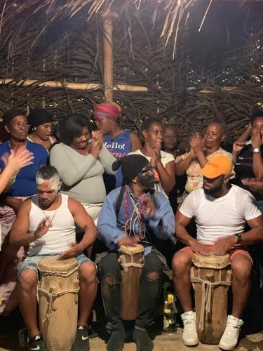 a group of people sitting around playing drums at Secreto Frente Al Mar in Cacique