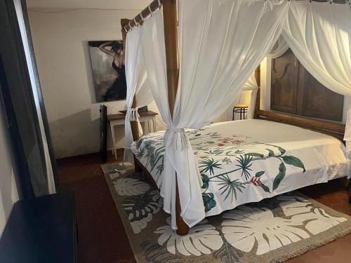 une chambre avec un lit à baldaquin dans l'établissement GITE de LAS TREILLES, à Puylaroque