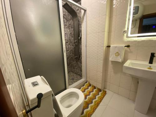 a small bathroom with a toilet and a sink at Résidence hôtelière MEDOM Palace, Bastos in Yaoundé