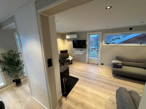 a living room with a couch and a television at Lyngenfjord Ski-To-Sea in Ysteby