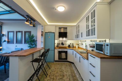 a kitchen with white cabinets and a blue refrigerator at Cozy Home in Oldtown Kaleici in Antalya