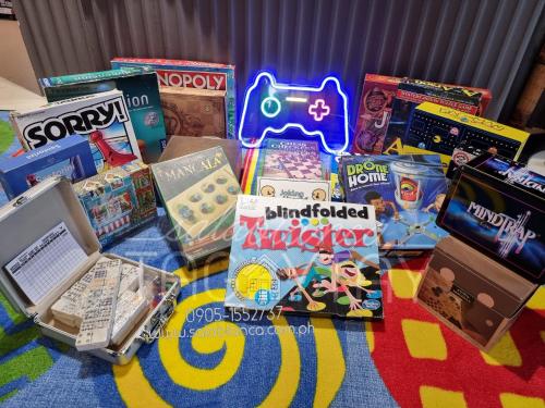 une pile de jeux et de livres sur une table dans l'établissement Salablanca Brand New Jacuzzi Heated Pool PS5 VR Cinema Fully AC Indoors Smart TVs with Netflix Disney Plus Large Balcony, à Tagaytay