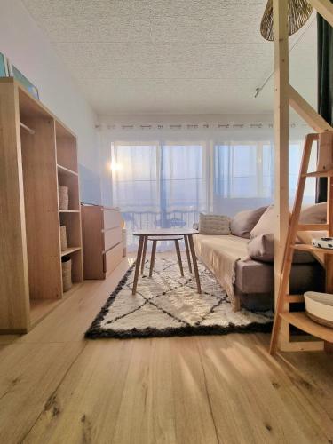 un salon avec un canapé et une table dans l'établissement Appartement Hyper Cosy - Vue mer panoramique 180, à Quiberon