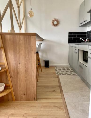 une cuisine avec une porte en bois au milieu dans l'établissement Appartement Hyper Cosy - Vue mer panoramique 180, à Quiberon