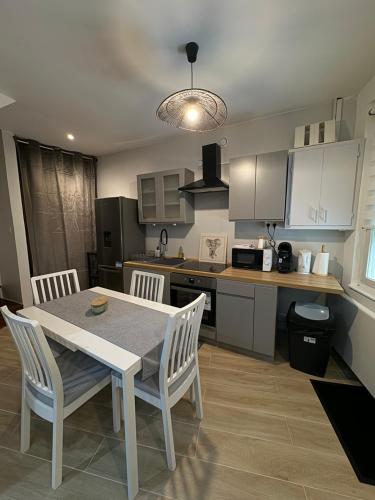 une cuisine avec une table et des chaises dans une cuisine dans l'établissement La maison du Bien être, à Bolbec
