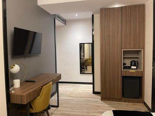 a room with a desk and a television in a room at PineHill Hotel, Restaurant , Pool & Spa - RAZEM in Razëm