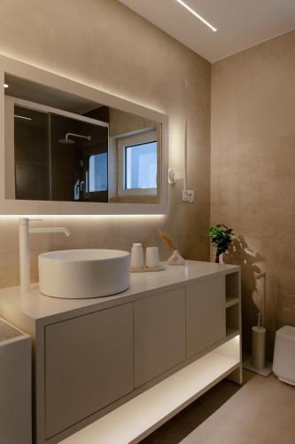 a bathroom with a white sink and a mirror at Villa Aldea Bali - Sea View - Private Pool in Vlikhádha