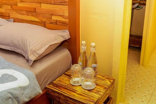 two bottles on a wooden table next to a bed at Amanya 2-Bedroom Self Catering Tent in Amboseli