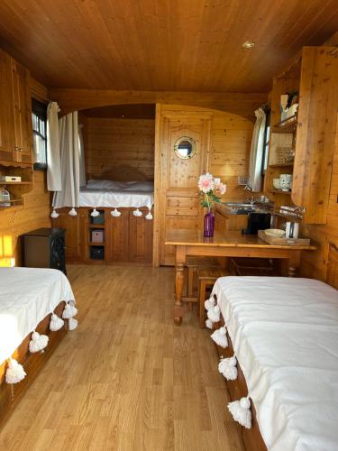 - une chambre avec 2 lits et un lavabo dans une cabine dans l'établissement Les Roulottes des amis de Wonky, à Rétaud
