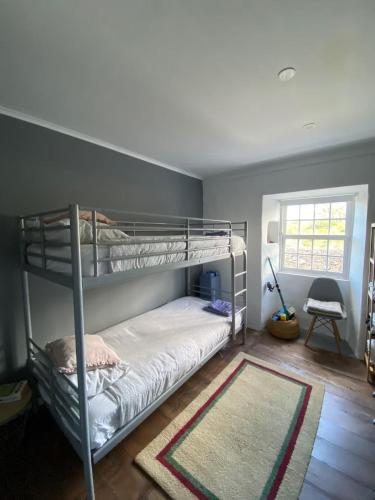 a bedroom with two bunk beds and a rug at Casa 3 Picos 1 in São Roque do Pico