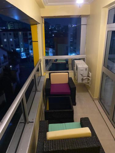 a room with a balcony with chairs and a window at Résidence hôtelière MEDOM Palace, Bastos in Yaoundé