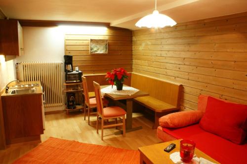 salon z czerwoną kanapą i stołem w obiekcie Appartement Schmiedhof w mieście Zell am See