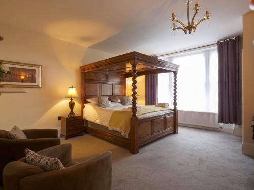 a bedroom with a canopy bed and a couch at The Black Boy Inn in Caernarfon