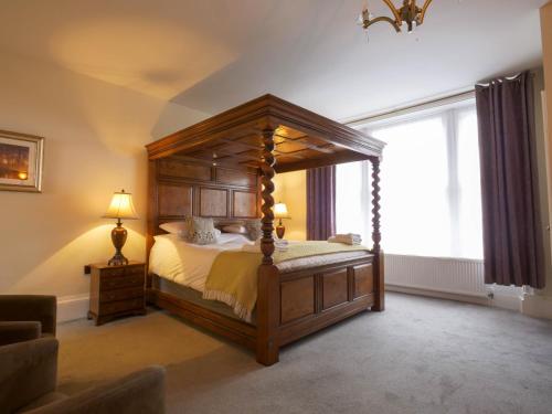 a bedroom with a canopy bed and a window at The Black Boy Inn in Caernarfon