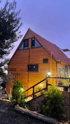 a wooden house with a sign on the side of it at Dana luxury huts in Dana