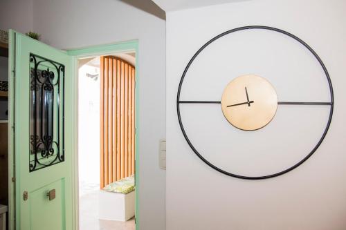 un reloj en una pared al lado de una puerta en Urban Oasis Suite, en Ermoupoli