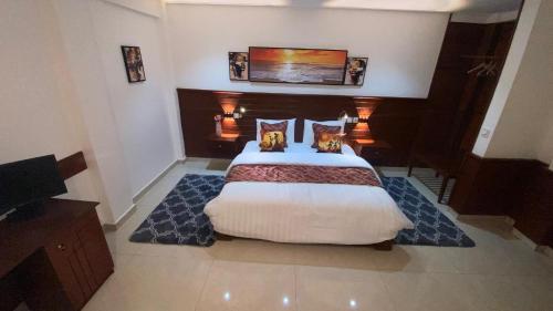 a bedroom with a large bed in a room at Résidence hôtelière MEDOM Palace, Bastos in Yaoundé