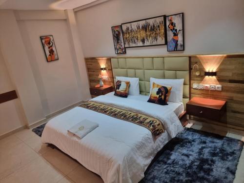 a hotel room with two beds and two lamps at Résidence hôtelière MEDOM Palace, Bastos in Yaoundé
