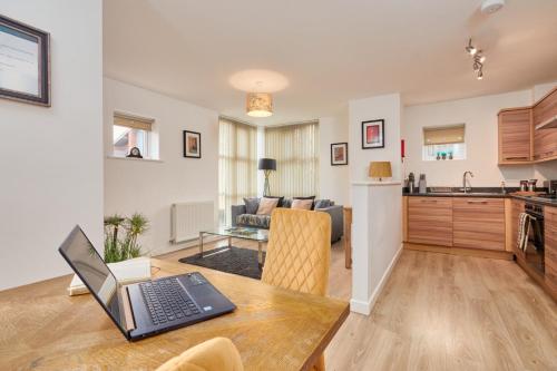 a kitchen and living room with a laptop on a table at Wilford View in Nottingham