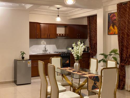 a kitchen with a dining room table and chairs at Résidence hôtelière MEDOM Palace, Bastos in Yaoundé