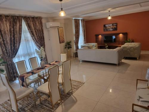 a living room with a table and chairs and a couch at Résidence hôtelière MEDOM Palace, Bastos in Yaoundé