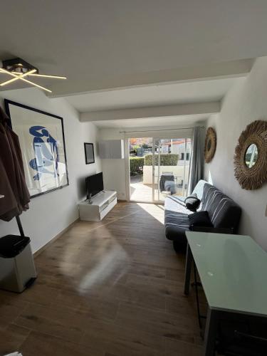 un salon avec un canapé et une table dans l'établissement Studio à côté de la plage, au Cap d'Agde