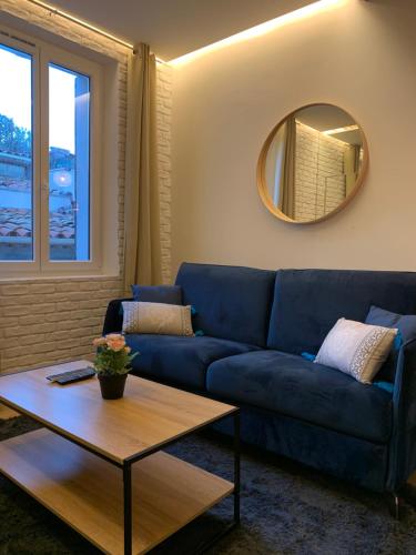 a blue couch in a living room with a mirror at Antibes Old Town Haven in Antibes