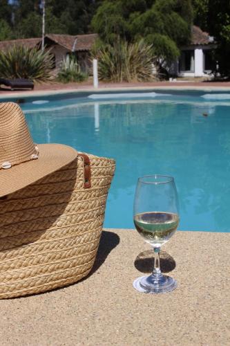 a glass of wine sitting on a table near a swimming pool at Hacienda Historica Marchigue in Marchihue