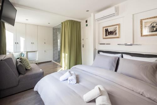 a hotel room with two beds and a couch at ROKOS SUPERIOR DOWNTOWN ROOMS - comfortable rooms with private bathrooms - perfect location for exploring Diocletian's Palace and the gastronomy of Split within walking distance in Split