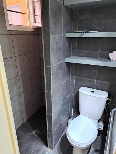 une salle de bain avec des toilettes blanches dans une chambre dans l'établissement Hameau du Puech, rez-de-jardin avec parking et clim, au Cap d'Agde