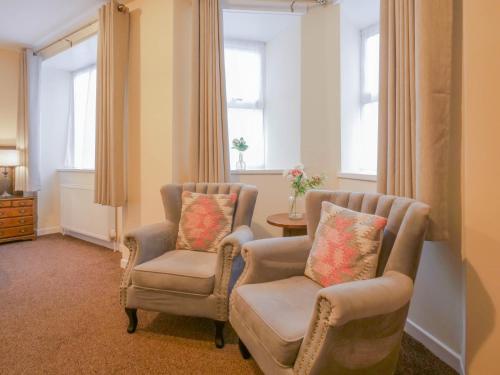 two chairs and a table in a room with windows at The Black Boy Inn in Caernarfon