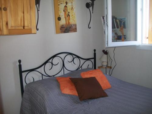 - une chambre avec un lit et un oreiller orange dans l'établissement Appartement St pierre la mer, à Fleury