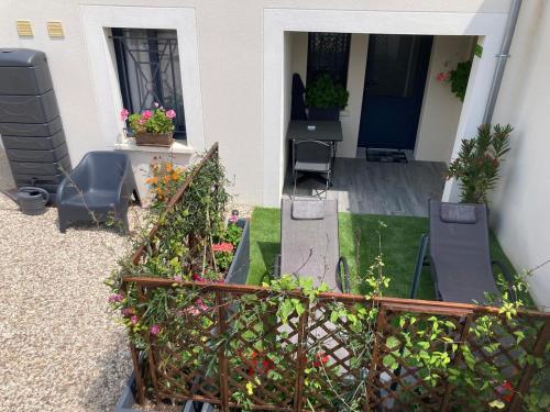 a balcony of a house with chairs and flowers at Le 3 Bis in Venoy