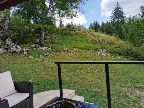 a view of a hill from a porch with a chair at Tara 1395 Altitude in Sekulić 