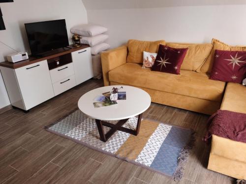 a living room with a couch and a table at Tara 1395 Altitude in Sekulić 
