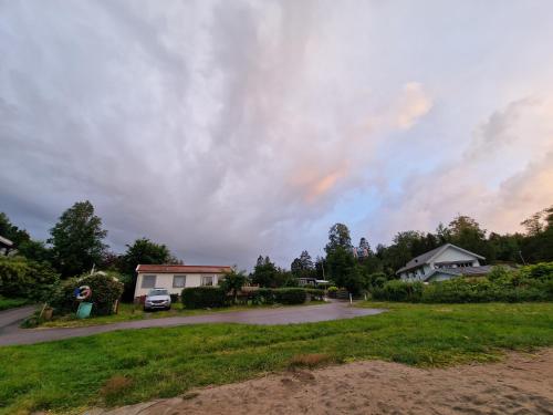a cloudy sky over a yard with houses at Trevligt fritidshus med underbar utsikt in Gothenburg