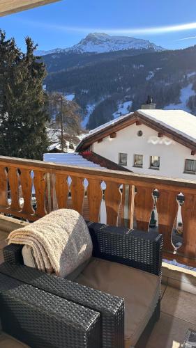 a couch on a balcony with a view of a mountain at Chalet apartment & mountain view in Saas
