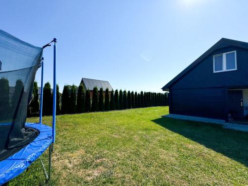 a tent in a yard next to a house at Nadmorska Kępa in Kąty Rybackie