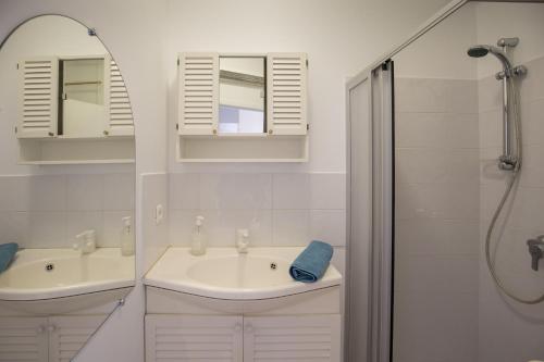 une salle de bain blanche avec un lavabo et une douche dans l'établissement Appartement T2 avec Vue Mer au Palais Lumière, à La Ciotat