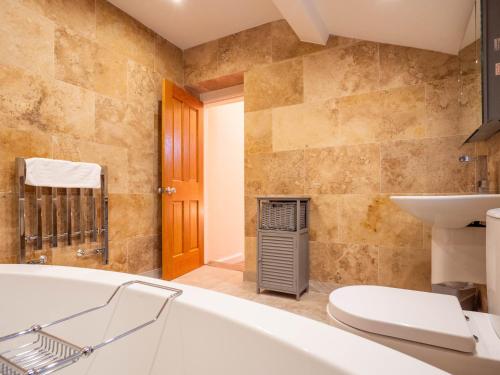 a bathroom with a tub and a toilet and a sink at The Black Boy Inn in Caernarfon