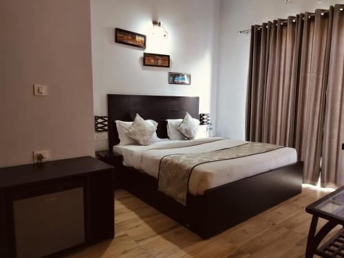una camera con letto king-size e tavolo di Ganret suites and resort a Vrindāvan