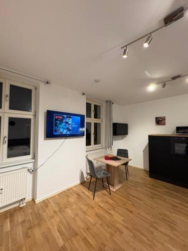 a room with a table and a tv on a wall at Modernes Serviced Apartment Wohnglück 2 in Ansbach