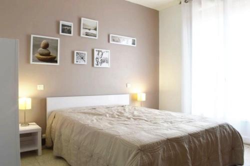 une chambre avec un lit et des tableaux au mur dans l'établissement NP620-312 Appartement 3 pièces Narbonne Plage, à Narbonne-Plage
