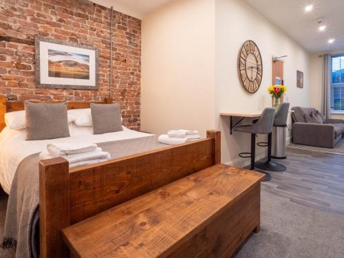 a bedroom with a bed and a brick wall at The Black Boy Inn in Caernarfon
