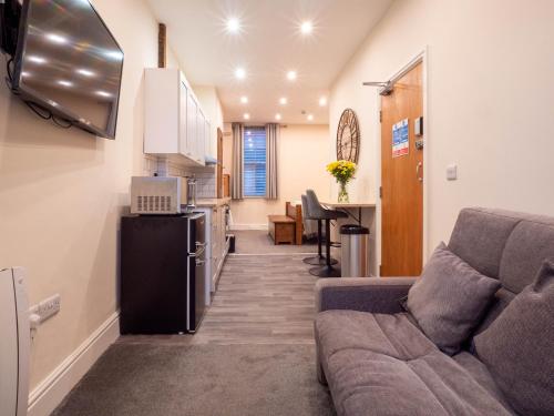 a living room with a couch and a kitchen at The Black Boy Inn in Caernarfon