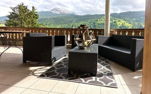 a balcony with chairs and a bowl on a table at Chalet apartment & mountain view in Saas